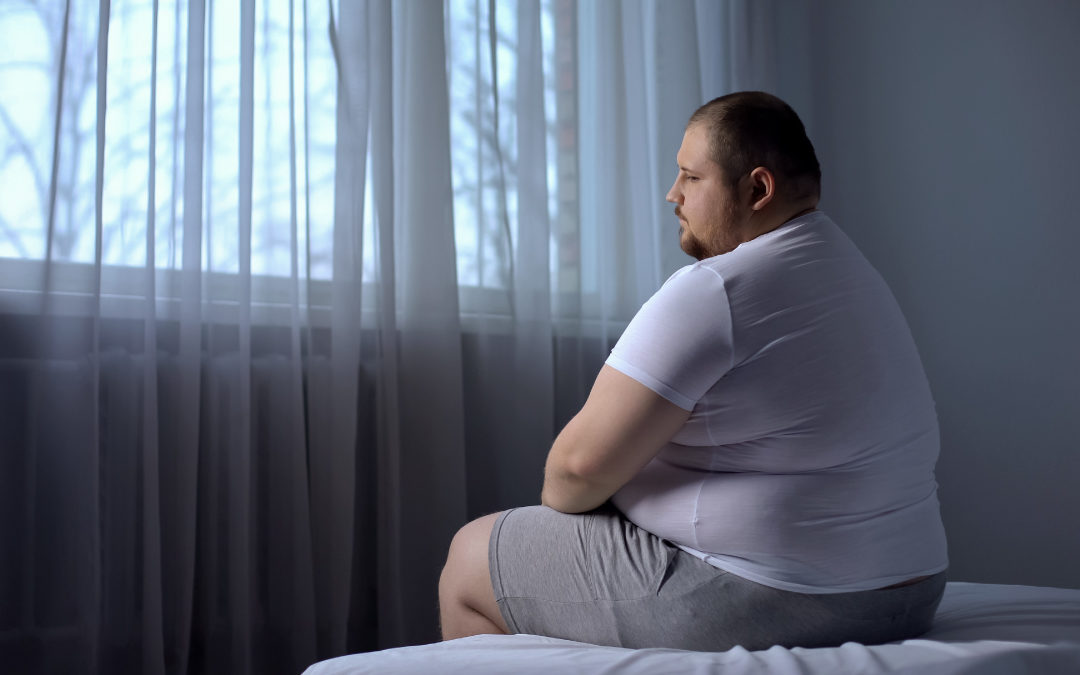 an obesity man on sitting on bed