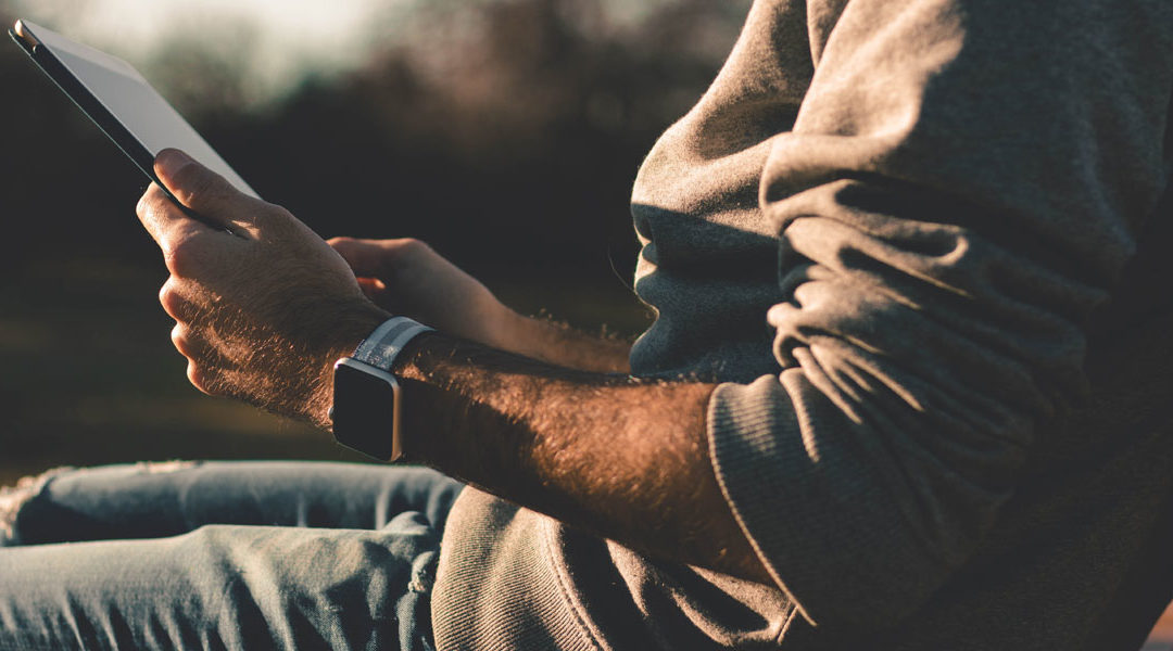 a man outside looking at his tablet